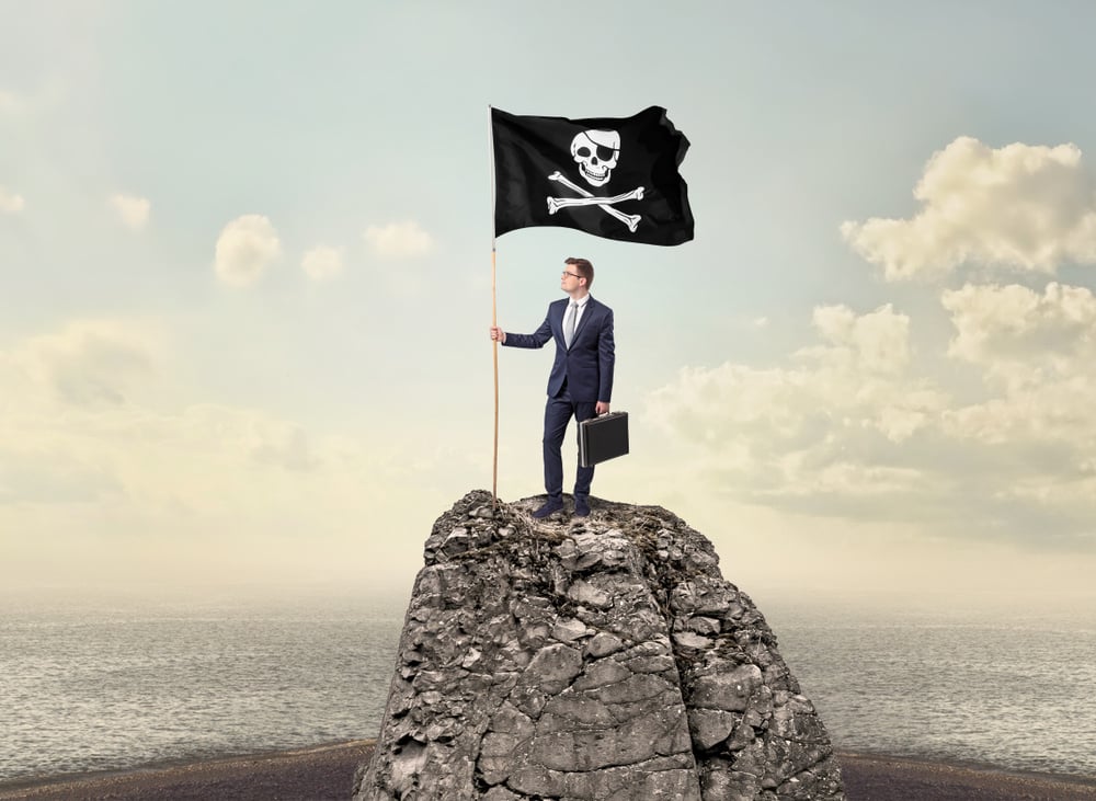 Successful businessman on the top of a mountain holding pirate flag Successful businessman on the top of a mountain holding pirate flag